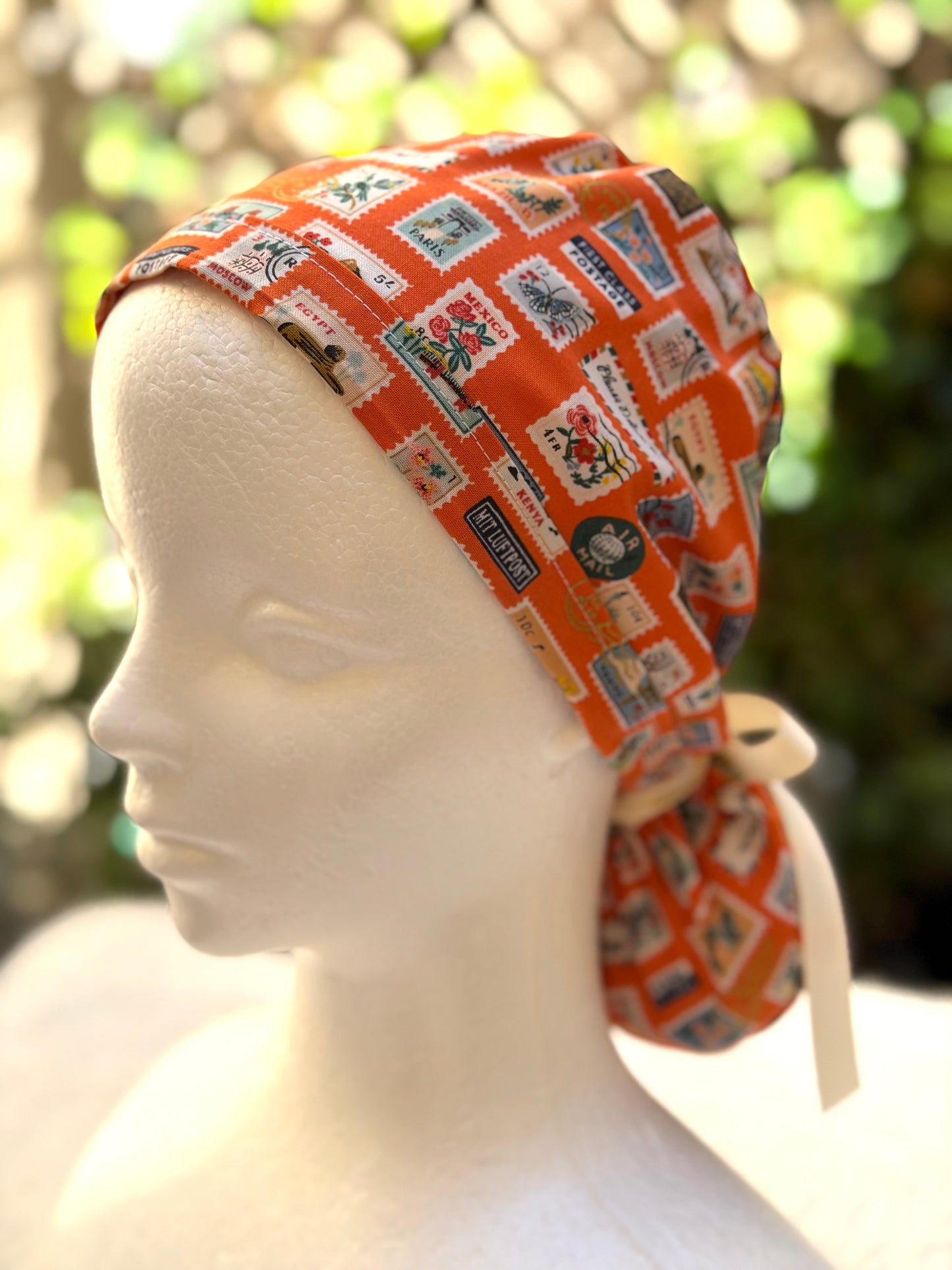 Orange postage stamps ponytail scrub cap