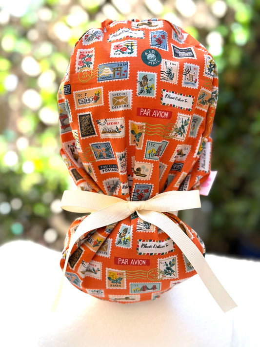 Orange postage stamps ponytail scrub cap