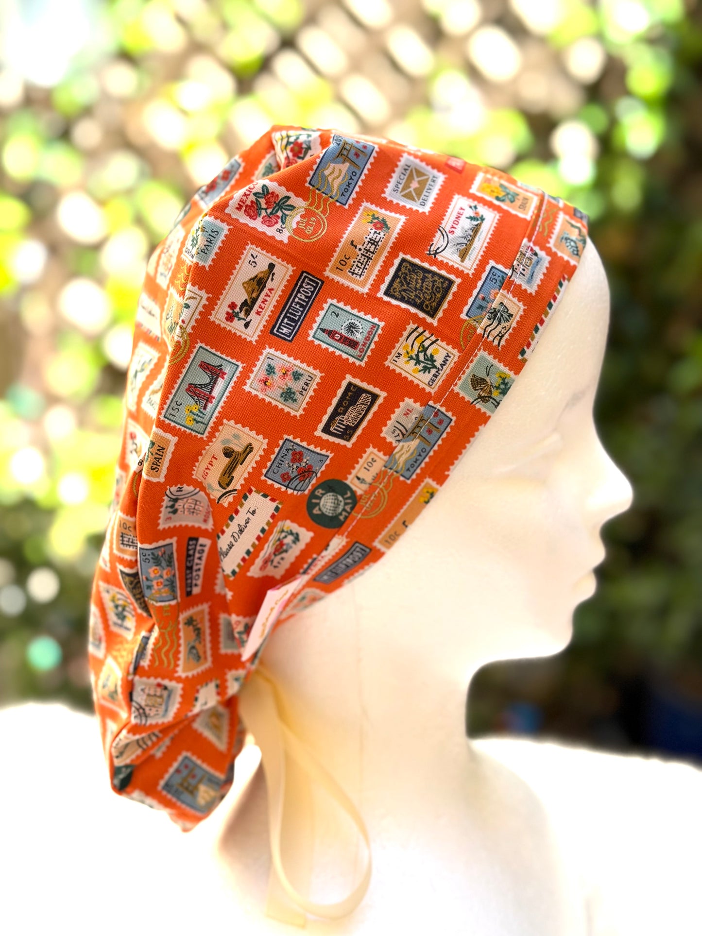 Orange postage stamps ponytail scrub cap