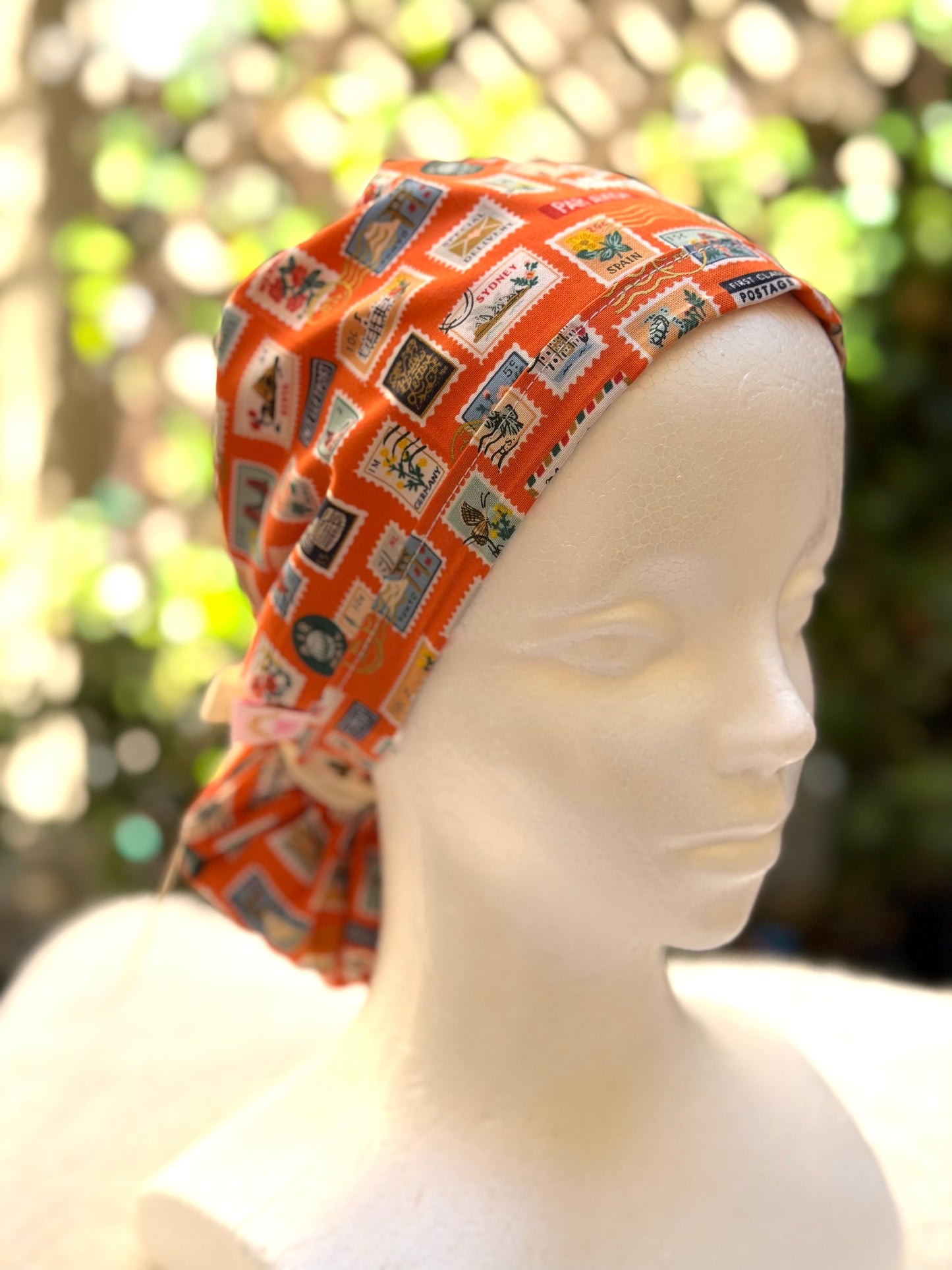 Orange postage stamps ponytail scrub cap