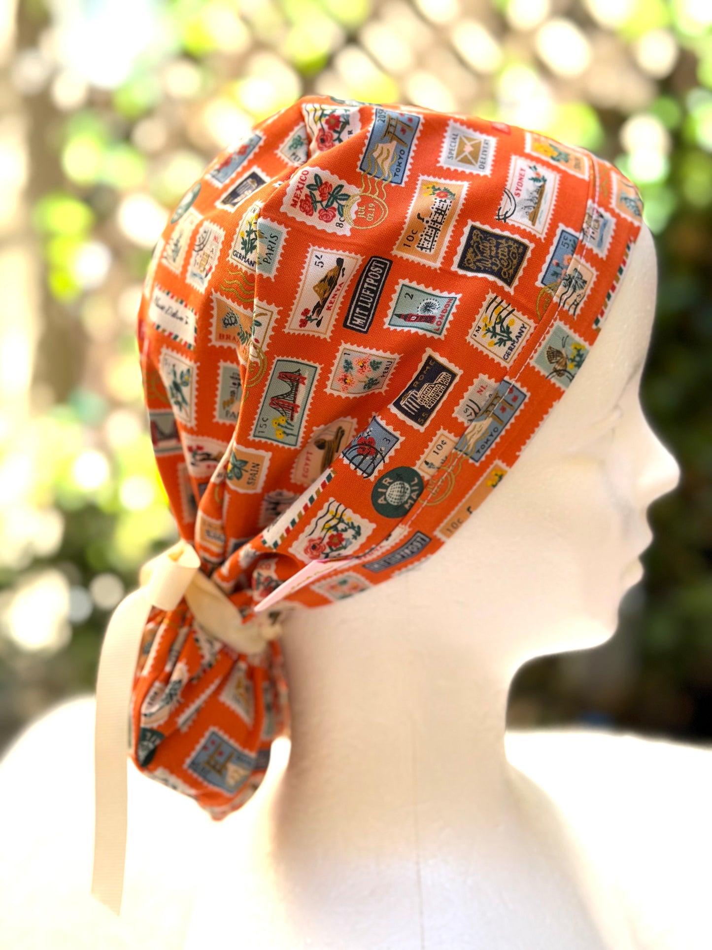 Orange postage stamps ponytail scrub cap