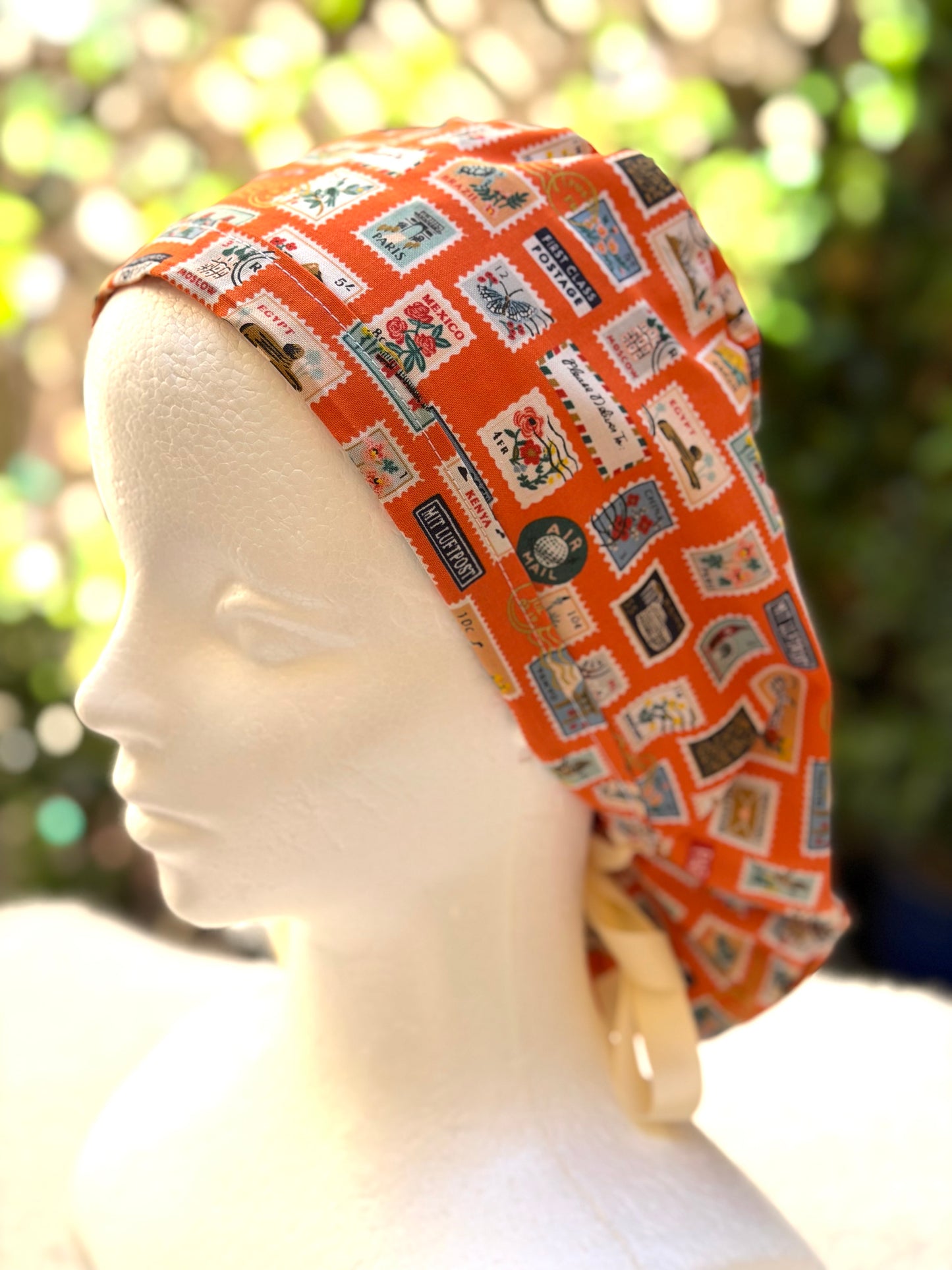 Orange postage stamps ponytail scrub cap