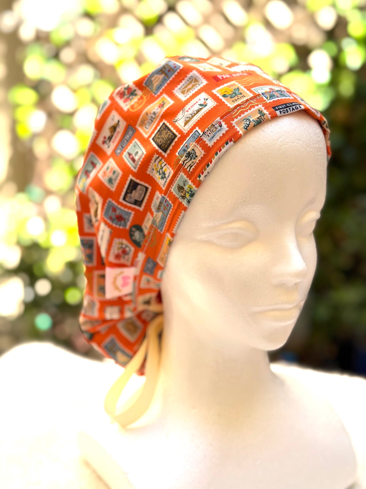 Orange postage stamps ponytail scrub cap